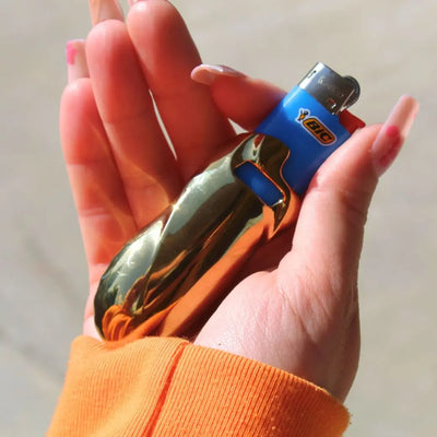 Goldfarbene Chromglanz Feuerzeughülle mit blauem Feuerzeug in der Hand