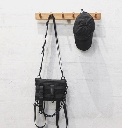 Schwarze MoveMate Tasche mit Gurten an der Wand hängend