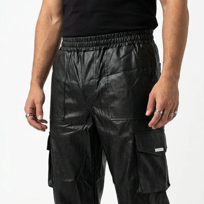 Schwarze Dark Groove Cargo Hose im Glanz-Look, Detail von Bund und Cargotasche am Model