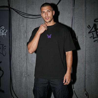 Schwarzes Techno Butterfly Oversize T-Shirt mit kleinem Falter vorne, Vorderansicht am Model #farbe_schwarz