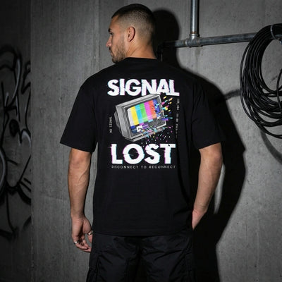 Schwarzes Signal Lost Oversize T-Shirt, Rückenprint am Model vor Betonwand #farbe_schwarz