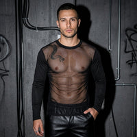 Schwarzes Sheer Vibe Langarmshirt mit transparentem Oberkörper, Vorderansicht am Model vor Betonwand