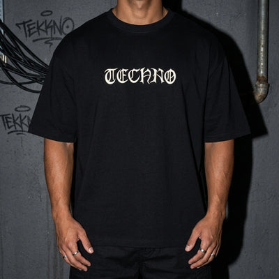 Schwarzes Techno Vibe Oversize T-Shirt, Detail des Brust-Schriftzugs am Model